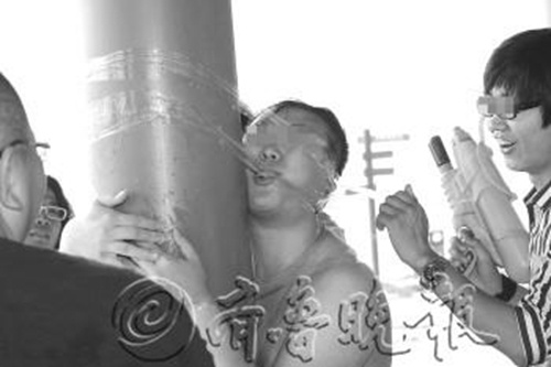 日照一新郎被闹婚者用胶带绑在柱子上。 本报记者 刘涛 摄 图片来源：齐鲁晚报