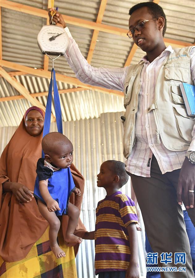 我胖了没 3月20日，在索马里边境城镇多洛的一处境内流离失所者营地，工作人员测量一名婴儿的体重。 记者 孙瑞博/摄